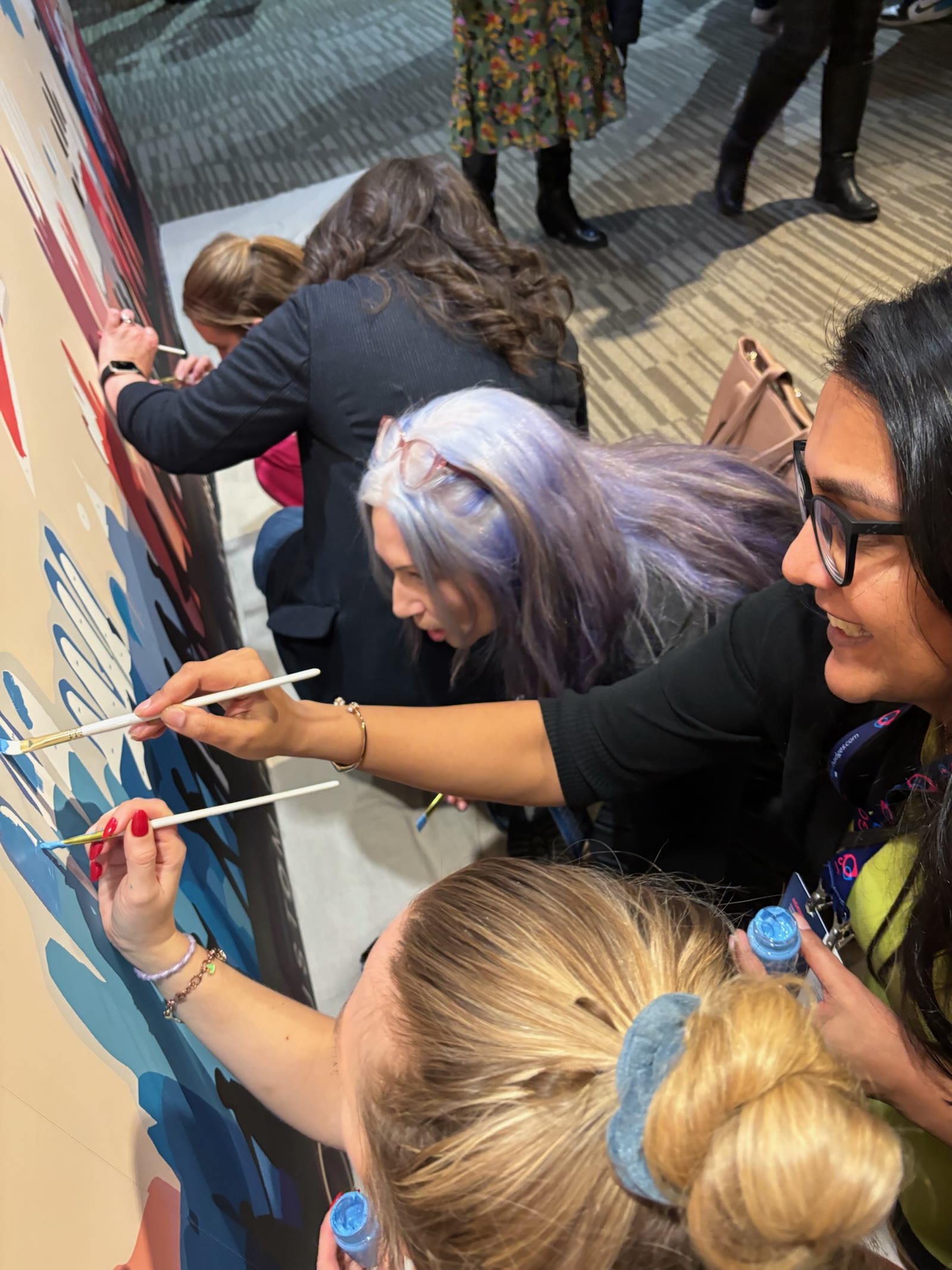 Boom team and partners painting together at a business event