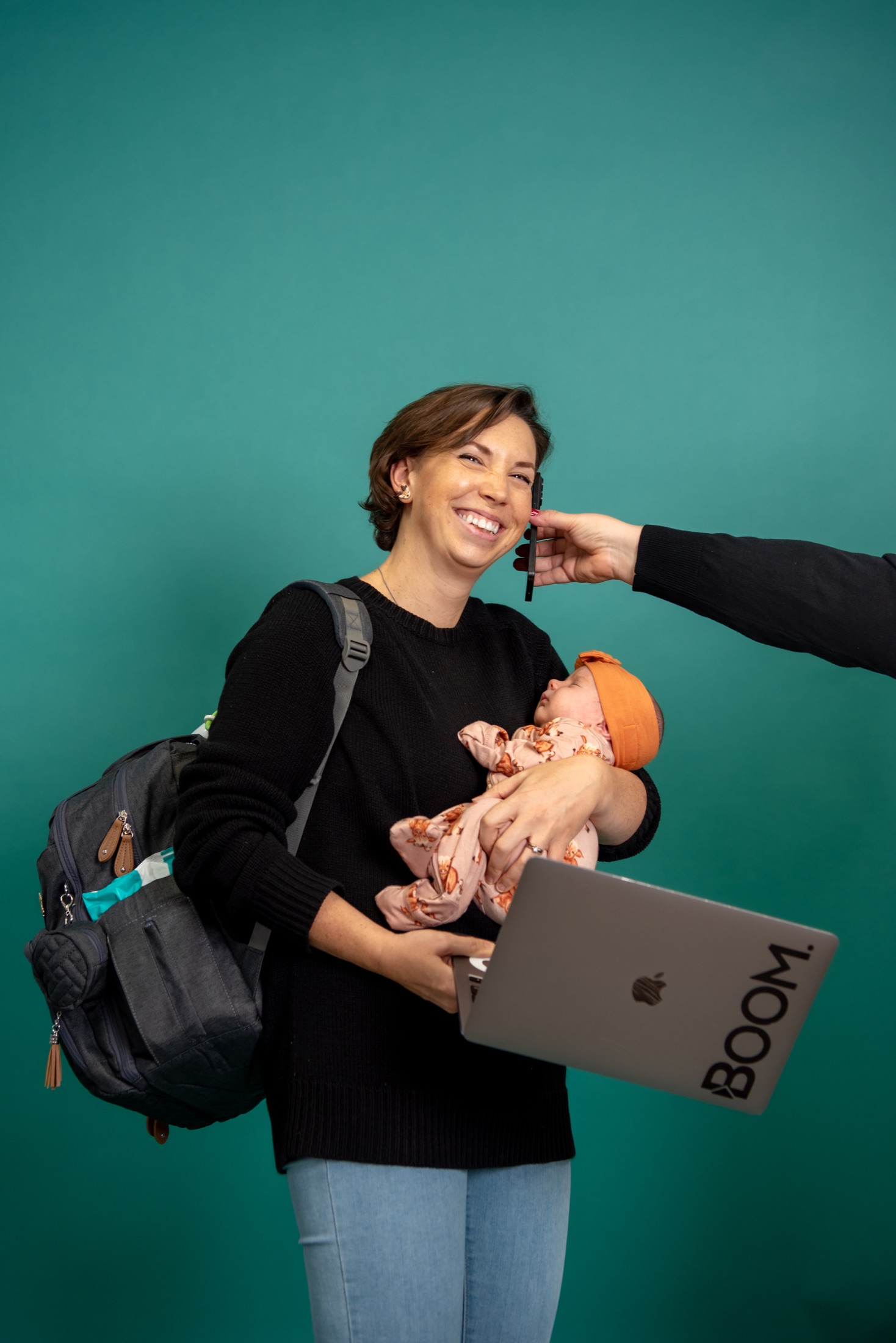 Boom teammate balancing a baby, laptop, and a busy day